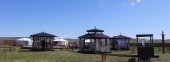 Buryat yurt is installed on decking floor in steppe by fence